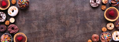 Çifte tatlı ve çeşitli şekerlemeler. Fotokopi alanı olan koyu taştan bir arkaplan üzerindeki en üst görünüm.