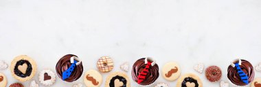 Babalar Günü temalı, çeşitli kurabiyeler ve tatlı ikramlarla alt sınırı pişirme temalı. Fotokopi alanı olan beyaz mermer afiş arkaplanındaki en üstten aşağı görünüm.