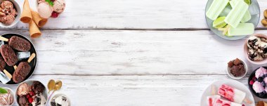 Serin yaz yemekleri çifte sınır. Çeşitli dondurma kaseleri, buzlu dondurmalar ve dondurulmuş ikramlar. Beyaz ahşap bir arkaplanda manzaranın üstünde. Boşluğu kopyala.