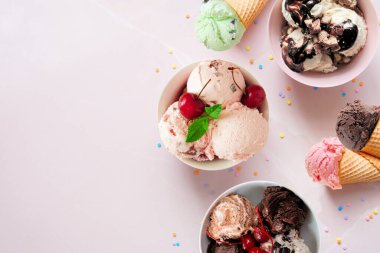 Yaz dondurması yan sınırı. Rengarenk kase ve koniler. Yumuşak pembe taştan arka planda üst manzara. Boşluğu kopyala.