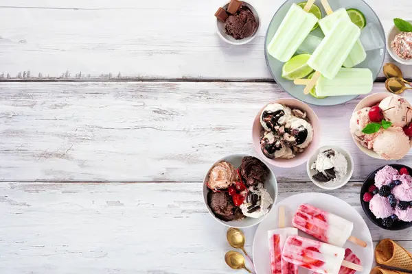 Soğuk yaz yemekleri sınırı. Çeşitli dondurma kaseleri, buzlu dondurmalar ve dondurulmuş ikramlar. Beyaz ahşap arka planda üst manzara. Boşluğu kopyala.