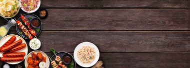 Koyu renk ahşap afiş üzerine yaz barbekü yemek köşesi sınırı. Çeşitli ızgara etler, salatalar ve kenarlar. Üst alt görünüm.