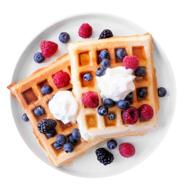 Taze böğürtlenli kahvaltı waffle 'ları ve beyaz tabakta krem şanti. Üst aşağı görünüm beyaz arkaplanda izole.
