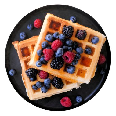 Siyah tabakta böğürtlenli, yaban mersinli ve böğürtlenli waffle. Beyaz arkaplanda izole edilmiş üst görünüm.