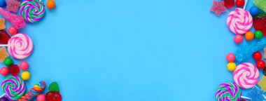 Renkli şeker grubu. Üst görünüm mavi afiş arkaplanı üzerinde çift kenar.