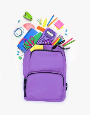 Okul malzemeleriyle dolu mor bir sırt çantası. Beyaz arka planda üstten aşağı. Okul konseptine dönelim..