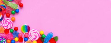 Renkli şeker koleksiyonu. Pembe bir arkaplan üzerinde köşedeki kenar üzerinde.