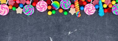 Renkli şeker koleksiyonu. Üst sınırın üzerinde siyah taştan bir afiş arkaplanı.