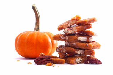 Sonbahar balkabağı baharatlı pekan cevizli şeker parçacıkları beyaz arka planda izole edilmiş.