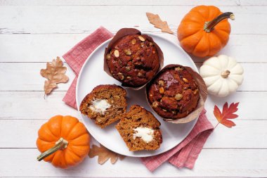 Krem peynir dolu sonbahar balkabağı kekleri. Beyaz ahşap arka planda tepeden aşağı görünüm.