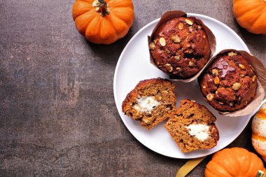 Krem peynir dolu sonbahar balkabağı kekleri. Kırsal bir arka planda tepeden aşağı manzara. Boşluğu kopyala.