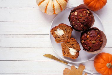Krem peynir dolu sonbahar balkabağı kekleri. Kırsal beyaz ahşap arka planda genel manzara. Boşluğu kopyala.