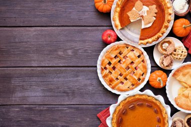 Ev yapımı sonbahar turtası sınırı. Fotokopi alanı olan koyu ahşap bir zemin üzerinde. Elmalı ve balkabaklı turtalar..