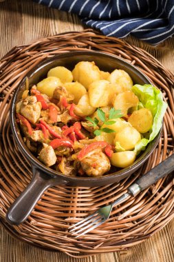 Kırmızı biberli ve soğanlı kızarmış tavuk parçaları, patates ile servis edilir..