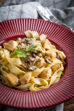 Orman mantarlı ve tavuklu Tagliatelle makarnası. Küçük alan derinliği.