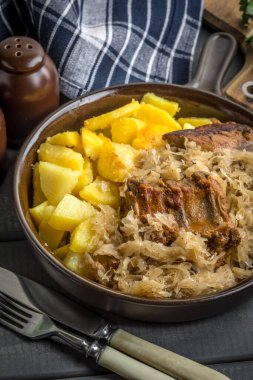 Kızarmış patatesle servis edilen lahana turşulu pirzola..