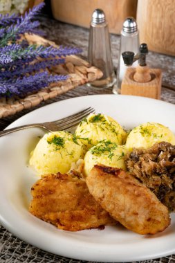 Kızarmış morina filetosu, haşlanmış patates ve mantarlı kızarmış lahana turşusu..