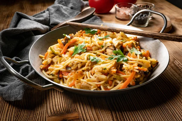 Fried noodles with chicken and vegetables. Chicken chow mein.