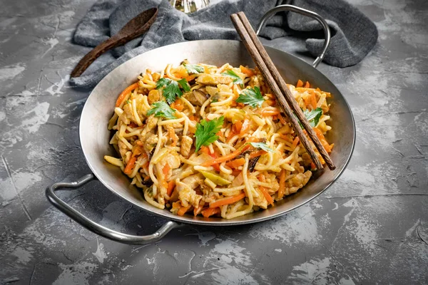 Fried noodles with chicken and vegetables. Chicken chow mein.