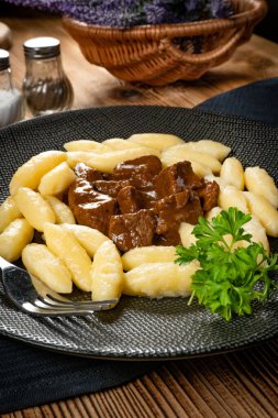 Soslu sığır eti yahnisi, patates köftesiyle servis edilir..