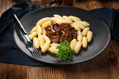 Soslu sığır eti yahnisi, patates köftesiyle servis edilir..