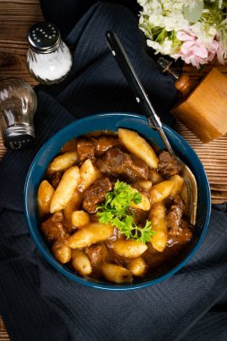 Soslu sığır eti yahnisi, patates köftesiyle servis edilir..