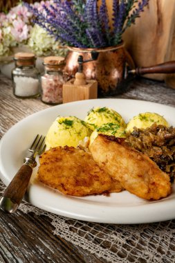 Kızarmış morina filetosu, haşlanmış patates ve mantarlı kızarmış lahana turşusu..