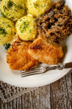 Kızarmış morina filetosu, haşlanmış patates ve mantarlı kızarmış lahana turşusu..