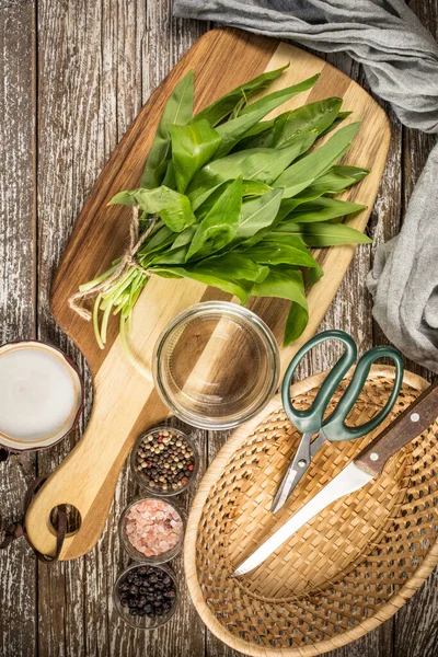 stock image Fresh wild garlic leaves on a wooden countertop.