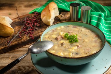 Sosis ve patatesli çavdar unundan yapılan ekşi çorba. Küçük alan derinliği.