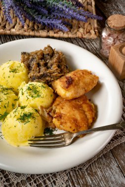 Kızarmış morina filetosu, haşlanmış patates ve mantarlı kızarmış lahana turşusu..