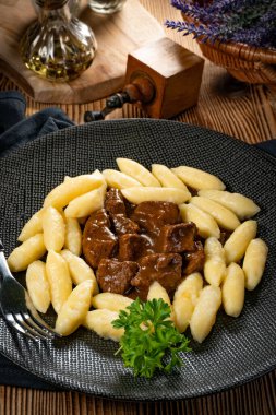 Soslu sığır eti yahnisi, patates köftesiyle servis edilir..