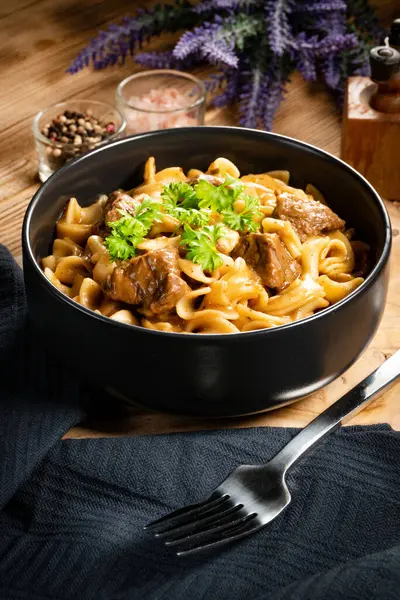 stock image Tagliatelle mosse with beef sauce on wooden table. Dark light.