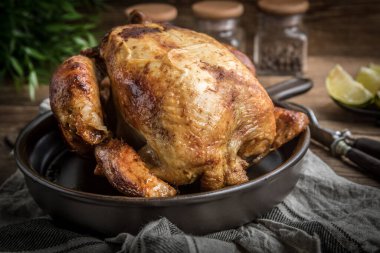 Ahşap masa üzerinde plaka üzerinde kavrulmuş tavuk.