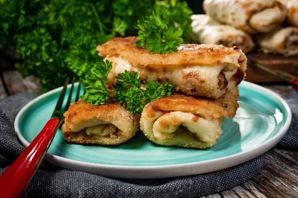 stock image Croquettes with mushrooms and sauerkraut on a dark plate.