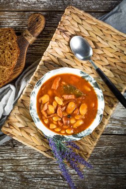 Domates soslu fasulye, pastırma ve sosis. Seçici odak.