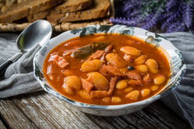 Domates soslu fasulye, pastırma ve sosis. Seçici odak.