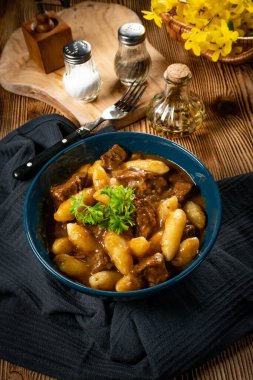 Soslu sığır eti yahnisi, patates köftesiyle servis edilir..