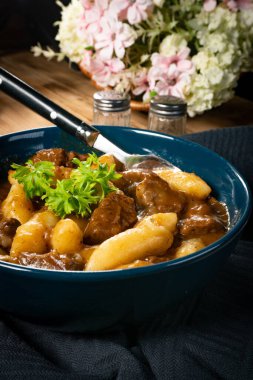 Soslu sığır eti yahnisi, patates köftesiyle servis edilir..