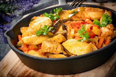 Dökme demir tavada sebzeli kızarmış tavuk..