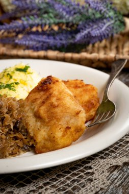 Kızarmış morina filetosu, haşlanmış patates ve mantarlı kızarmış lahana turşusu..