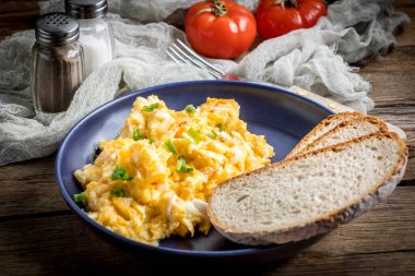 Sahanda yumurta soğan ve Frenk soğanı ile mavi tabakta ekmek ile servis.