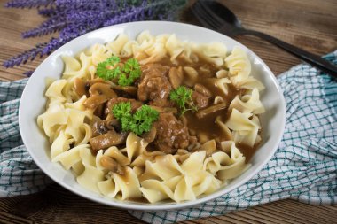 Tagliatelle yosunuyla servis edilen kendi soslu mantarlı domuz köftesi..