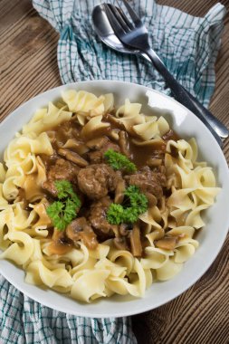 Tagliatelle yosunuyla servis edilen kendi soslu mantarlı domuz köftesi..