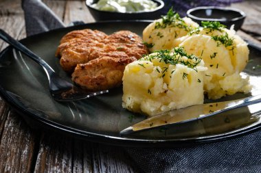 Domuz pirzolası, patates püresi ve salatalık salatasıyla servis edilir..