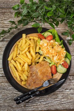 Geleneksel Polonya yemeği: kızarmış domuz pirzolası, patates kızartması ve salata ile servis edilir.. 