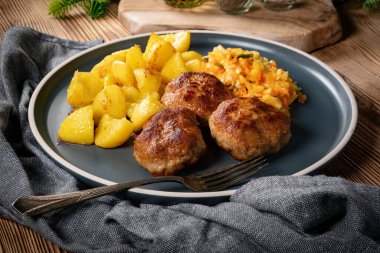 Tabakta patates kızartmasıyla servis edilen köfteler..