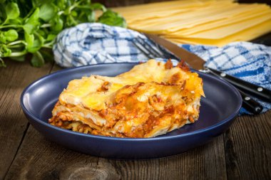 Kırmızı şarap ile lezzetli sıcak lazanya parçası. Küçük alan derinliği.