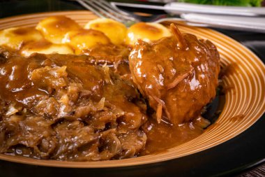 Silezya eriştesi ve kızarmış lahana ile servis edilen sığır rölesi..