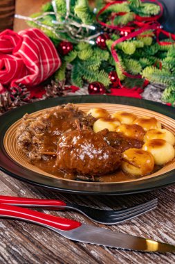 Silezya eriştesi ve kızarmış lahana ile servis edilen sığır rölesi..